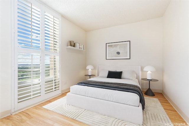 bedroom featuring wood-type flooring and a textured ceiling