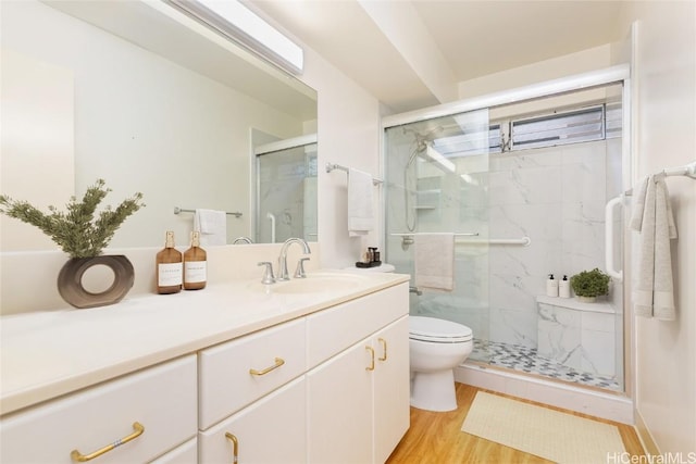 bathroom featuring hardwood / wood-style floors, vanity, toilet, and a shower with door