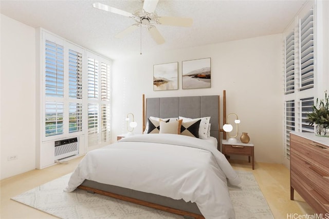 bedroom featuring ceiling fan, an AC wall unit, a textured ceiling, and light carpet