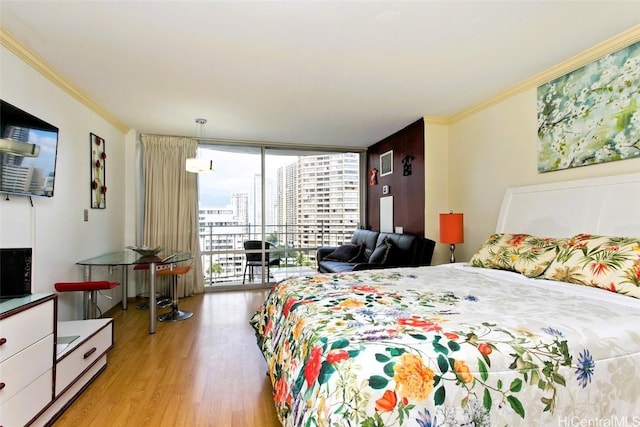 bedroom featuring access to exterior, light wood-type flooring, a wall of windows, and crown molding