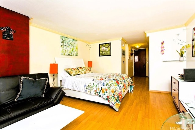 bedroom with crown molding and light hardwood / wood-style flooring