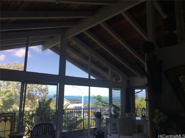 interior space with vaulted ceiling with beams and a water view