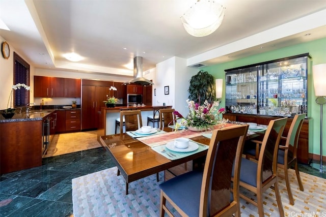 dining area with a tray ceiling and sink