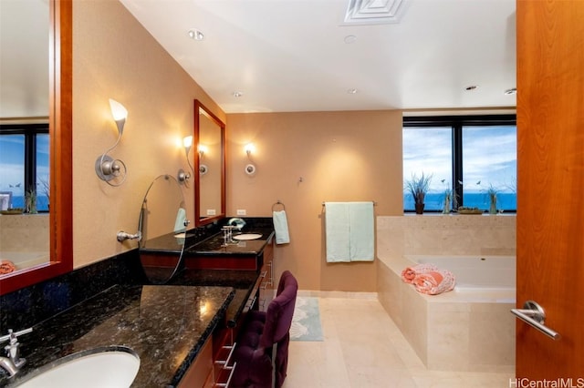 bathroom with tile patterned floors, tiled bath, and vanity