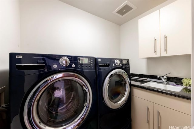 washroom featuring cabinets, independent washer and dryer, and sink