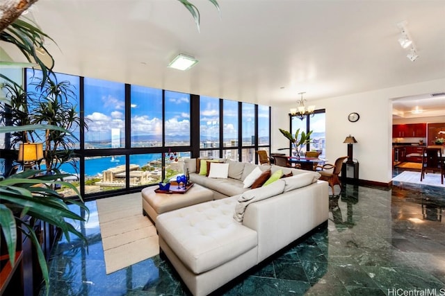 living room featuring expansive windows, a water view, and a chandelier