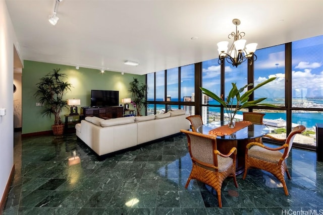 living room with expansive windows, rail lighting, and an inviting chandelier