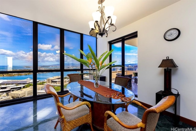 dining area with a notable chandelier and a water view