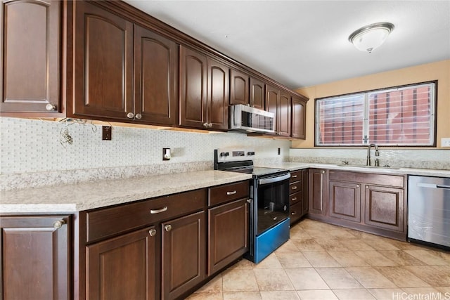 kitchen featuring dark brown cabinetry, sink, stainless steel appliances, backsplash, and light tile patterned floors