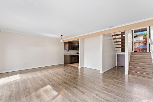 unfurnished living room with crown molding and light hardwood / wood-style flooring