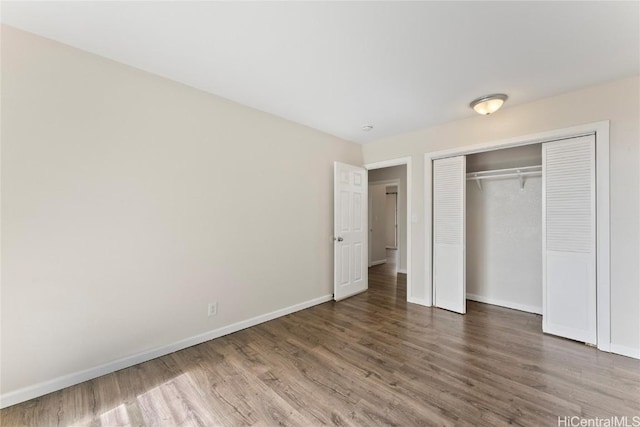 unfurnished bedroom featuring wood-type flooring and a closet