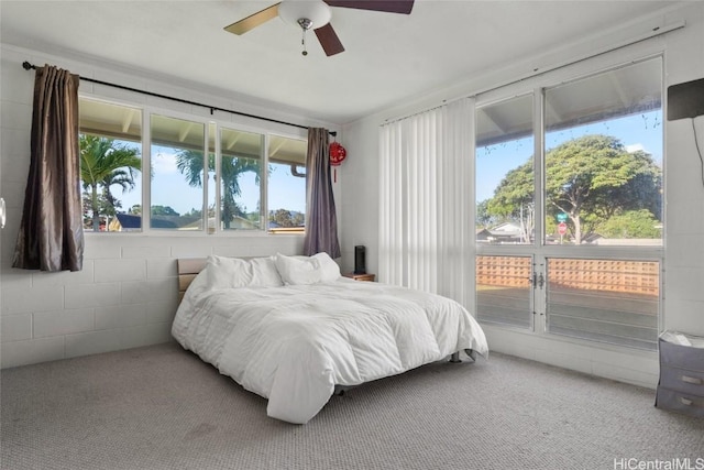 carpeted bedroom featuring multiple windows and ceiling fan