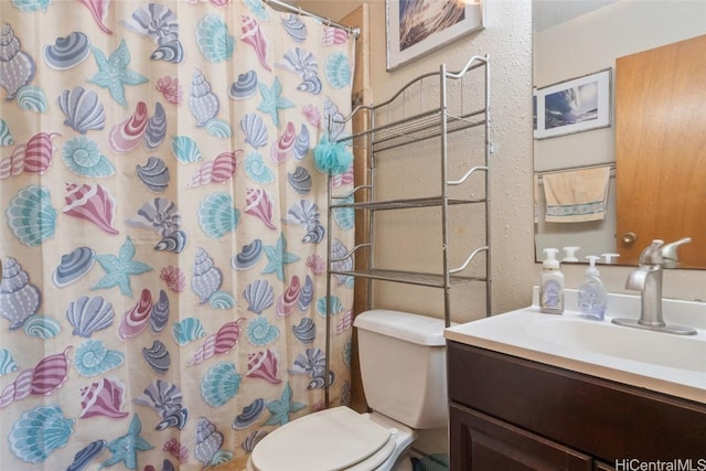 bathroom featuring a shower with curtain, vanity, and toilet