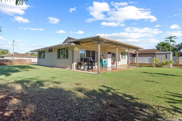 rear view of property with a yard and a patio area