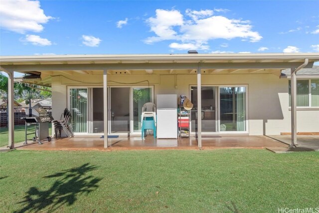 rear view of property with a lawn and a patio