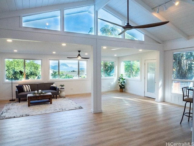 sunroom / solarium featuring ceiling fan, lofted ceiling with beams, and wooden ceiling