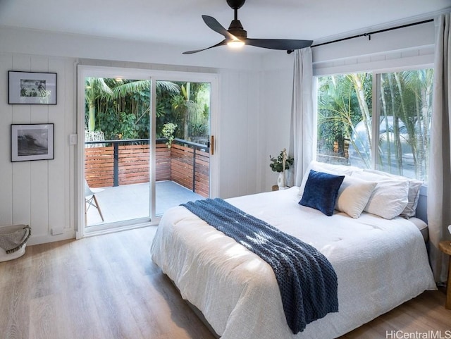 bedroom with multiple windows, ceiling fan, hardwood / wood-style floors, and access to exterior