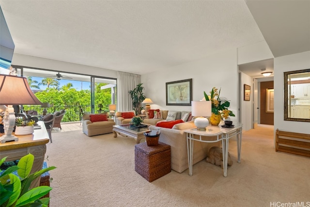 living room featuring ceiling fan, light colored carpet, and a textured ceiling