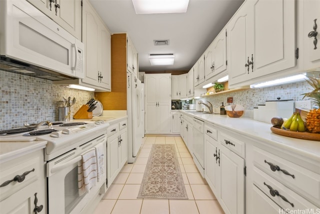 kitchen with white cabinetry, sink, backsplash, white appliances, and light tile patterned floors