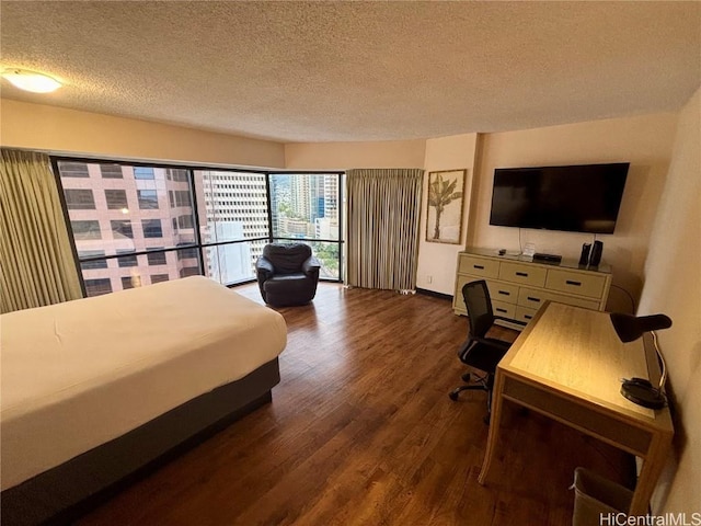 bedroom featuring a textured ceiling, dark hardwood / wood-style flooring, and access to outside