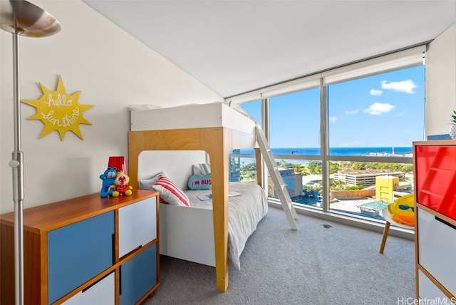 bedroom featuring carpet, floor to ceiling windows, and a water view