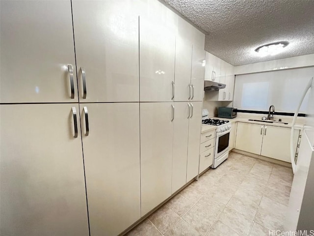 kitchen with gas range gas stove, light countertops, a sink, a textured ceiling, and under cabinet range hood