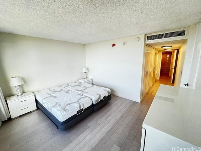 bedroom with wood-type flooring and a textured ceiling