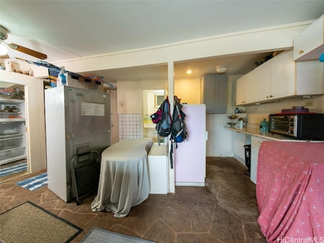 interior space with white cabinets and ceiling fan