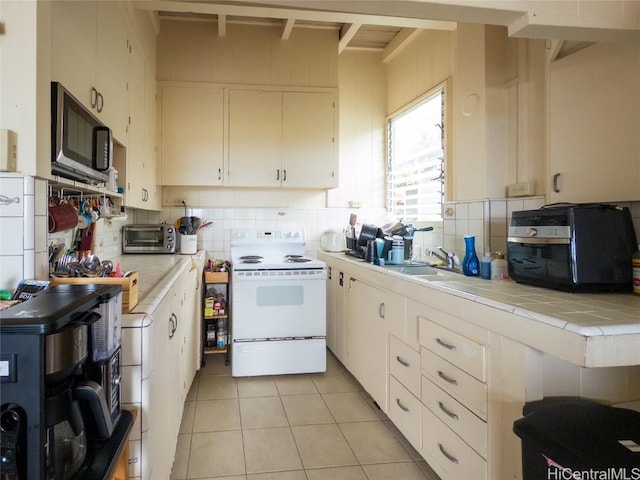 kitchen with sink, white electric range, white cabinetry, tile counters, and light tile patterned flooring