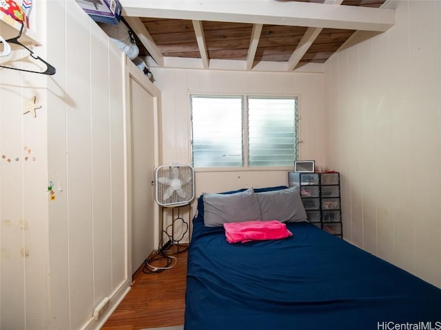 bedroom featuring beam ceiling, wood walls, hardwood / wood-style floors, and wood ceiling