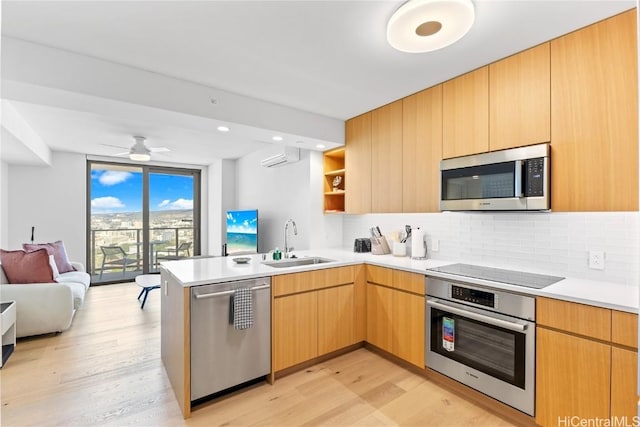 kitchen with light hardwood / wood-style floors, sink, kitchen peninsula, and stainless steel appliances