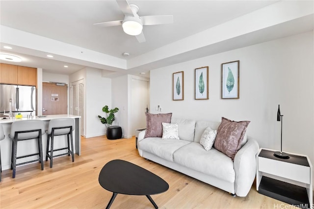 living room featuring ceiling fan and light hardwood / wood-style flooring