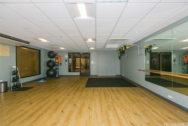 exercise room featuring a paneled ceiling and wood-type flooring