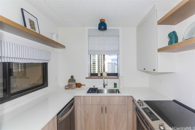 kitchen featuring white cabinets, sink, a textured ceiling, light brown cabinetry, and stainless steel appliances