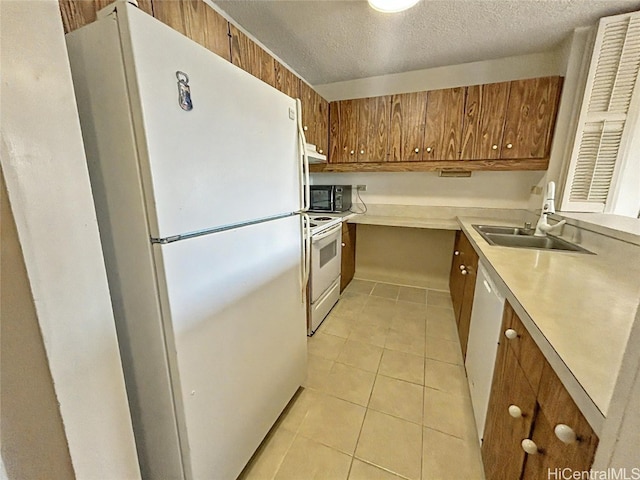 kitchen with white appliances, ventilation hood, sink, light tile patterned floors, and a textured ceiling