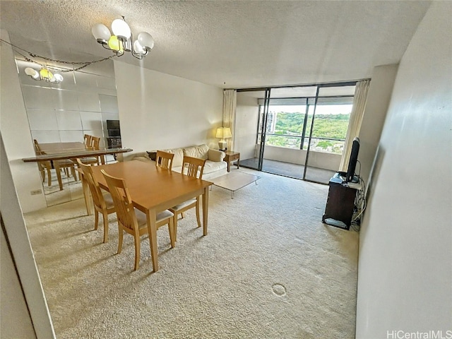 carpeted dining room featuring a chandelier and a textured ceiling