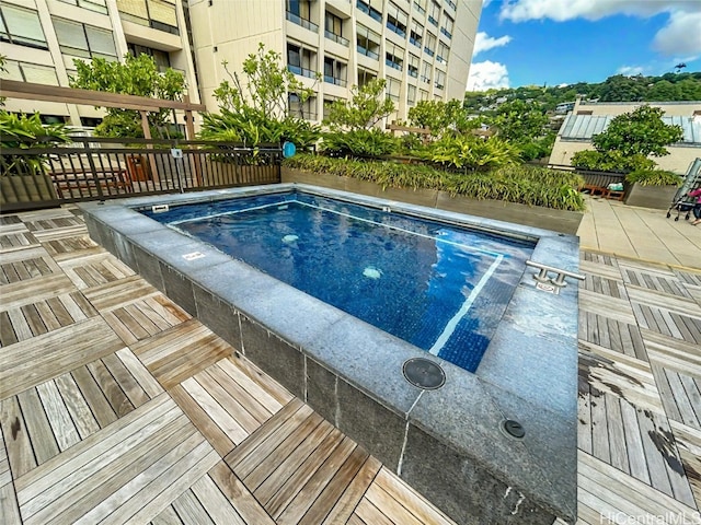 view of pool with a hot tub