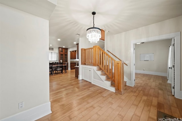 stairway with a chandelier and hardwood / wood-style floors