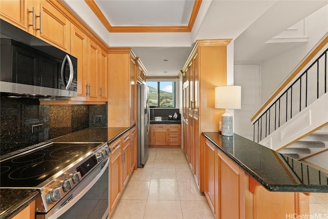 kitchen featuring tasteful backsplash, ornamental molding, dark stone counters, stainless steel appliances, and light tile patterned floors