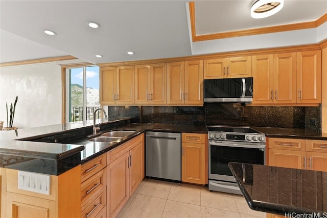 kitchen with kitchen peninsula, backsplash, dark stone counters, stainless steel appliances, and sink