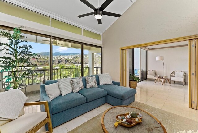 tiled living room with a mountain view, ceiling fan, and high vaulted ceiling