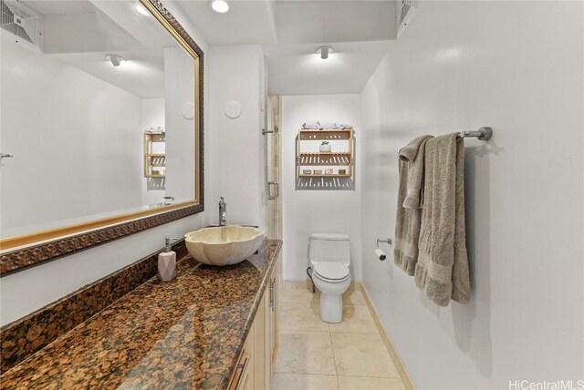 bathroom featuring tile patterned flooring, vanity, and toilet