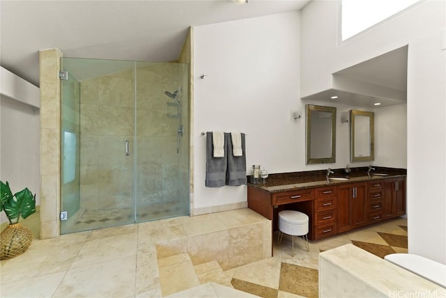 full bath with a stall shower, a sink, baseboards, and double vanity