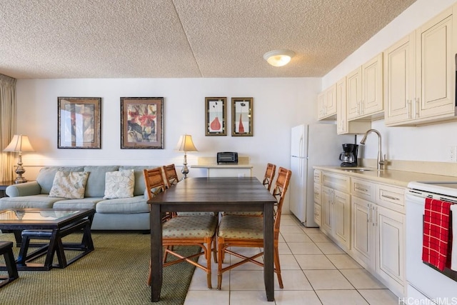 tiled dining room with sink and a textured ceiling