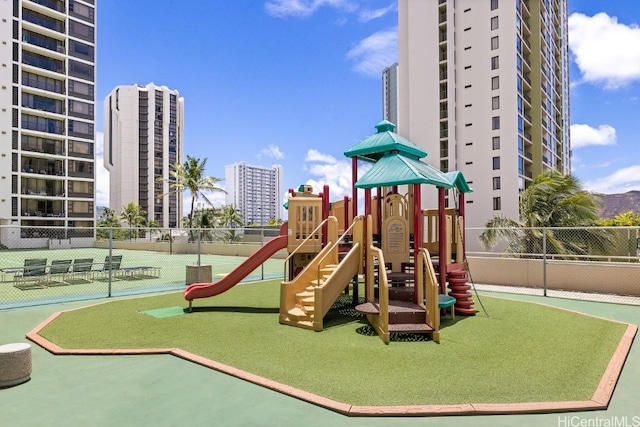 view of jungle gym featuring tennis court