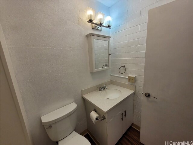 half bath featuring vanity and toilet