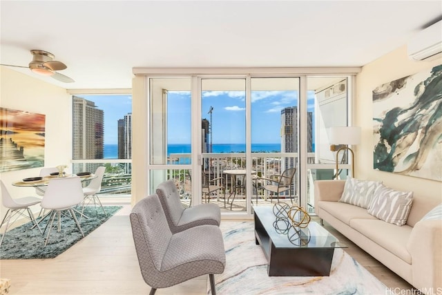 living room with plenty of natural light, a wall mounted air conditioner, hardwood / wood-style flooring, floor to ceiling windows, and a water view