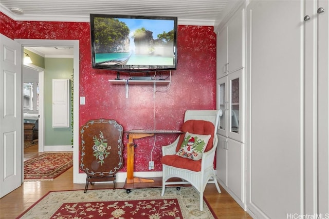 living area featuring hardwood / wood-style flooring and crown molding