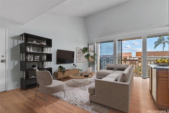 living room with light hardwood / wood-style floors and lofted ceiling