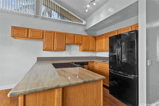 kitchen featuring kitchen peninsula, dark wood-type flooring, and black appliances